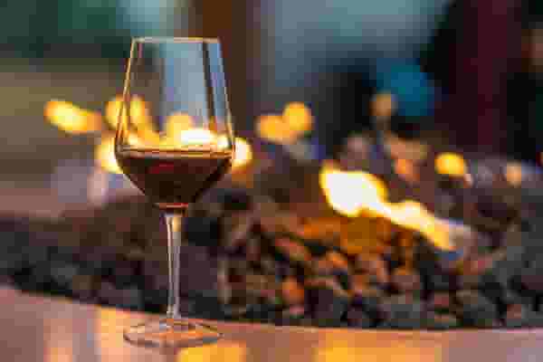Residents drinking wine around the fire at 805 Riverfront
